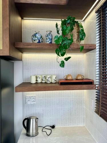 a kitchen with wooden shelves with blue and white dishes at Tropicana Hồ Tràm - Seashell Villa in Ho Tram