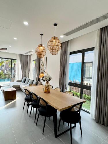 a living room with a wooden table and chairs at Tropicana Hồ Tràm - Seashell Villa in Ho Tram