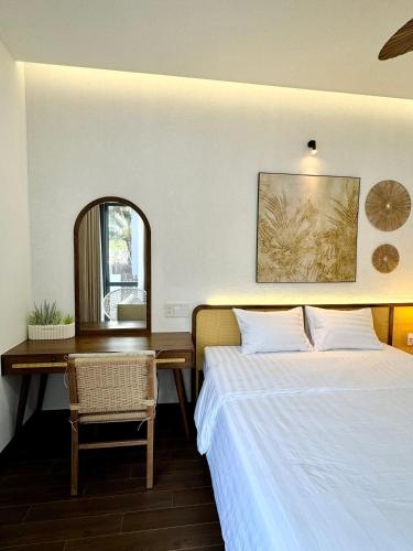 a bedroom with two beds and a desk and a mirror at Tropicana Hồ Tràm - Seashell Villa in Ho Tram