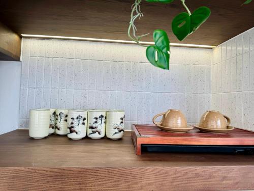 a group of vases and tea pots on a shelf at Tropicana Hồ Tràm - Seashell Villa in Ho Tram