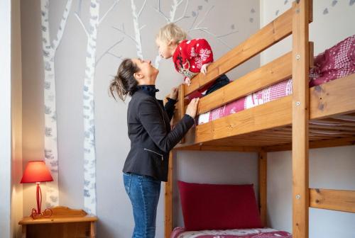 a woman standing next to a bunk bed at Bed & Breakfast Tiffany in Domodossola
