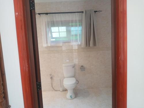 a bathroom with a toilet and a window at Benjamine's Guesthouse in La Digue