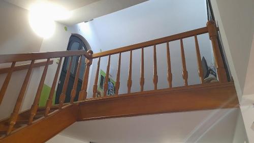 a stairway with a wooden railing in a house at Apartmani Delas 2 in Pješčana Uvala 