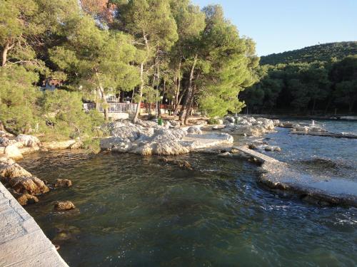 a river with rocks and trees and a bridge at Apartment studio Mia-beach in Split in Split