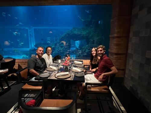 a group of people sitting at a table in an aquarium at PINOKKIO B&B Restaurant in Jimbaran