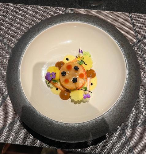 a plate with a crab on it with flowers on it at PINOKKIO B&B Restaurant in Jimbaran