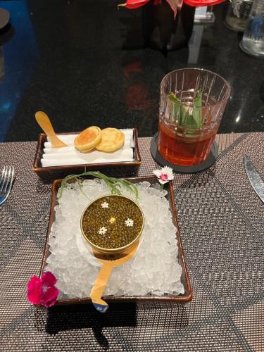 a table with a plate of food and a drink at PINOKKIO B&B Restaurant in Jimbaran