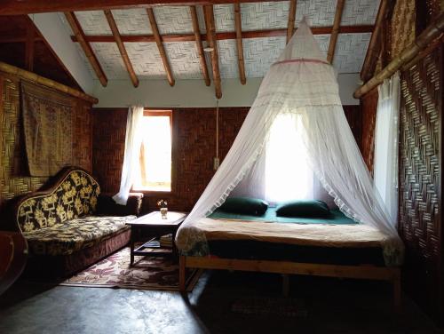 a bedroom with a bed with a mosquito net at Magpie homestay in Bukit Lawang