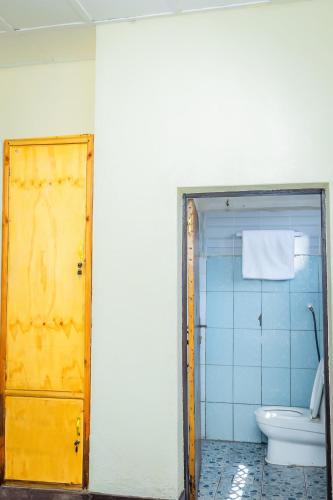 a bathroom with a yellow door and a toilet at Rhoja homes in Ruhengeri