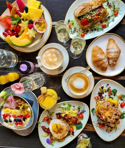 a table with plates of breakfast foods and a cup of coffee at Hotel Forstinger - Boutique Hotel Schärding in Schärding
