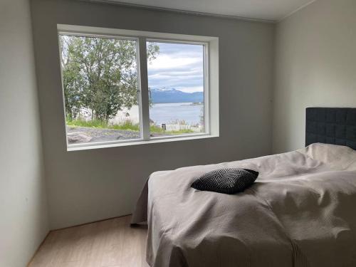 a bedroom with a bed and a large window at Villa Northern Light in Tromsø