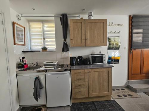 a kitchen with a sink and a stove top oven at Studio de 23 m² au centre de Montfort L'amaury in Méré