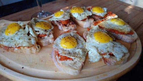 a wooden plate with eggs on top of bread at Domaine Le Clos du Figuier Spa Grisolles in Verdun-sur-Garonne