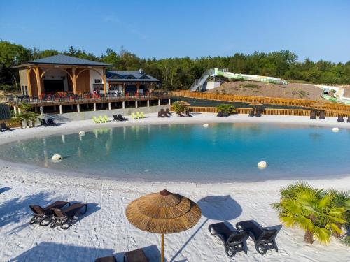 - une grande piscine avec des chaises et un parasol sur une plage dans l'établissement Camping Campilo - Maeva, à Aubigny