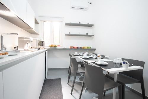 a kitchen with a table and chairs in a kitchen at BMode in Catania