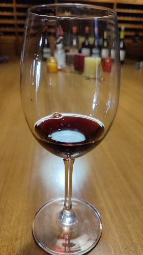 a glass of wine sitting on a wooden table at Αρχοντικό Ταξίμι (Μουντζουρίδη) in Argalasti