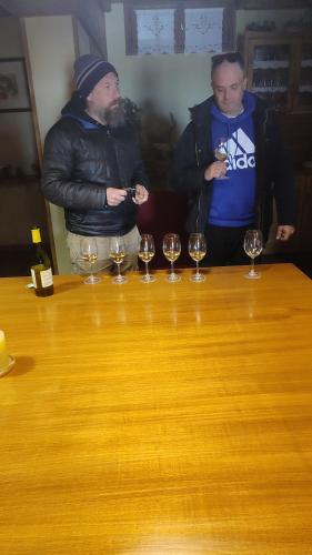 two men standing next to a table with wine glasses at Αρχοντικό Ταξίμι (Μουντζουρίδη) in Argalasti