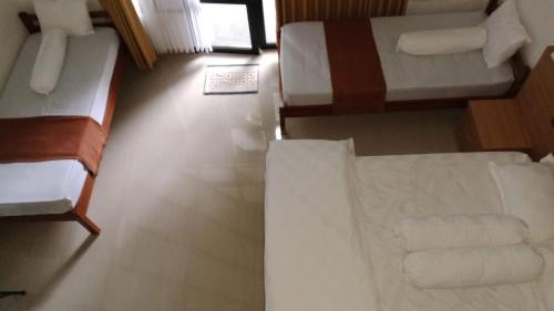 een kamer met 2 bedden en een bank bij Jon's Paradise Villa and Resto in Sajang