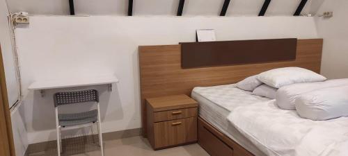 een kleine slaapkamer met een bed en een bureau bij Jon's Paradise Villa and Resto in Sajang