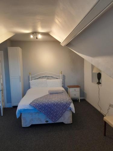 Singleton Short Stay Loft R10 في سوانسي: غرفة نوم بسرير أبيض وعلوي