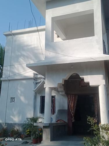 Casa blanca con puerta y ventana en Shruti Guest House, en Dublāt