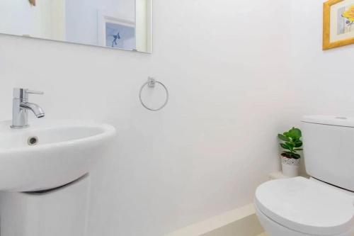 een witte badkamer met een wastafel en een toilet bij Сharming & Peaceful 3BDR flat near Wembley station in Londen
