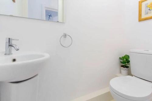 a white bathroom with a sink and a toilet at Сharming & Peaceful 3BDR flat near Wembley station in London