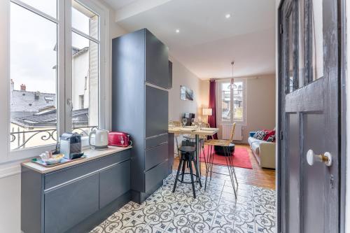 - une cuisine avec un comptoir et une table dans une pièce dans l'établissement Le Petit Bacchus - au cœur de Nantes, à Nantes