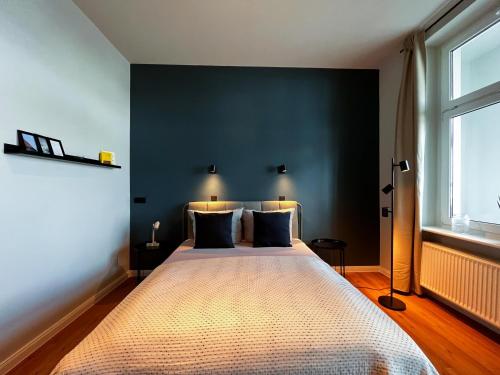 a bedroom with a large bed with a black wall at Studios am Hafen in Stralsund
