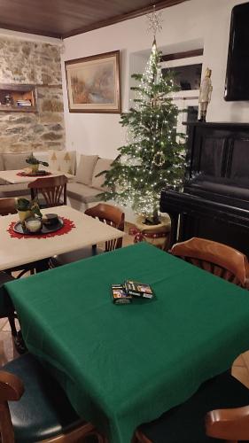 a living room with a green table and a christmas tree at Αρχοντικό Ταξίμι (Μουντζουρίδη) in Argalasti