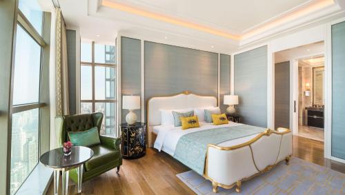 a bedroom with a king sized bed and a green chair at The St. Regis Shanghai Jingan in Shanghai