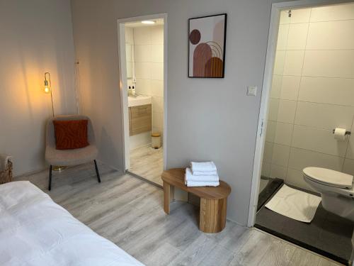 ein Bad mit einem Bett, einem WC und einem Tisch in der Unterkunft High Street Apartments in Zandvoort