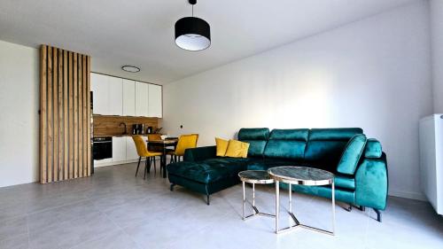 a living room with a green couch and a table at Kolo Apartament Gold in Koło