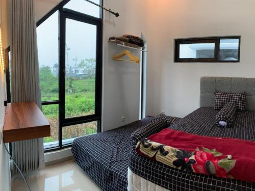 a bedroom with a bed and a large window at Villa Estetis di Kota Batu in Malang
