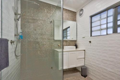 y baño con ducha acristalada y lavamanos. en 2 Bedroom House with 2 E-Bikes Included at Centre of Chippendale, en Sídney