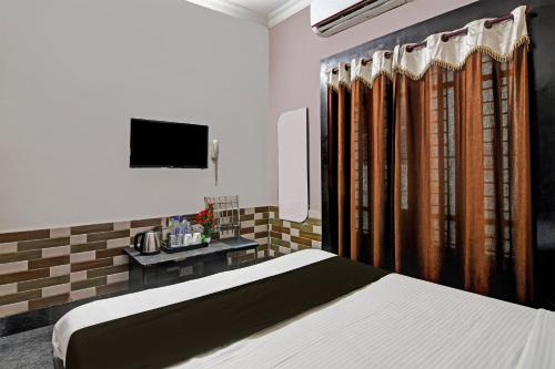 a bedroom with a bed and a television in it at Hotel O Regal Stays in Khandagiri