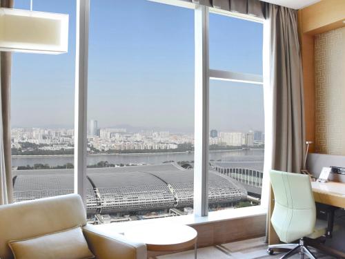 a room with a desk and a large window at Langham Place Guangzhou - Walking distance to Canton Fair in Guangzhou