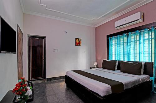 a bedroom with a large bed with pink walls at Hotel O Regal Stays in Khandagiri