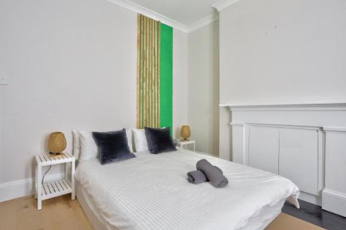 雪梨的住宿－2 Bedroom House with 2 E-Bikes Included at Centre of Chippendale，一间卧室配有一张白色的床和绿色的墙壁