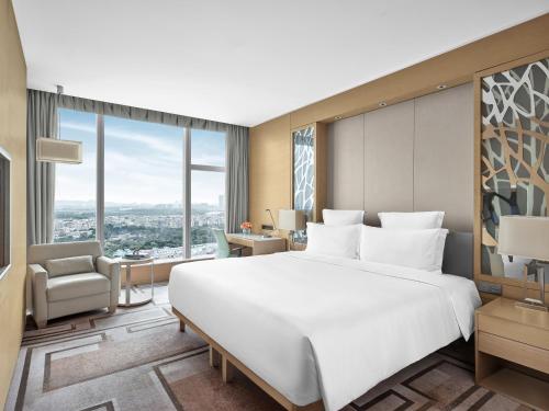a bedroom with a large white bed and a large window at Langham Place Guangzhou - Walking distance to Canton Fair in Guangzhou