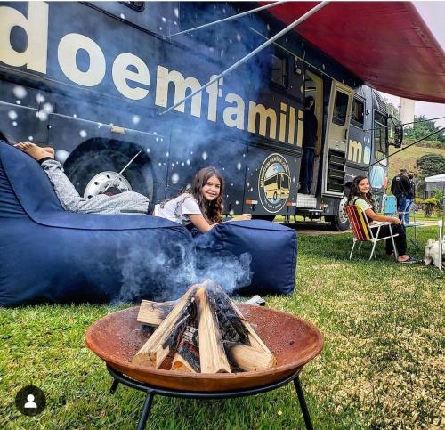 a woman laying on a couch in front of an rv at Motorhome Mundo em Família in São Roque