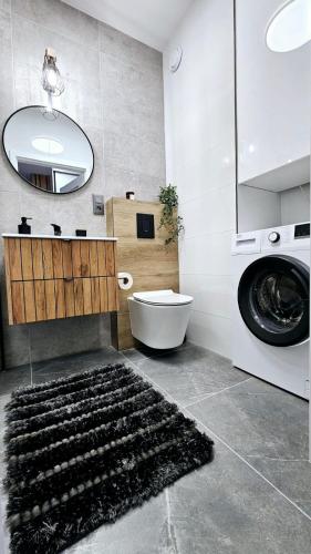 a bathroom with a sink and a washing machine at Kolo Apartament Gold in Koło