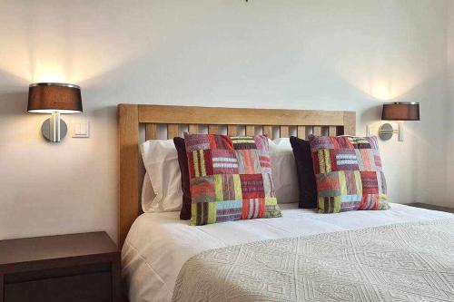 um quarto com uma cama com 2 almofadas e 2 candeeiros em Fantástica V3 Vista Mar Golfe Praia Del Rey em Amoreira