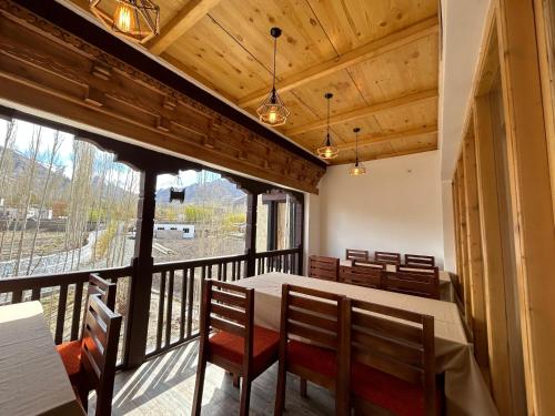 una sala da pranzo con tavolo e sedie e una grande finestra di Shalla Heritage a Stak