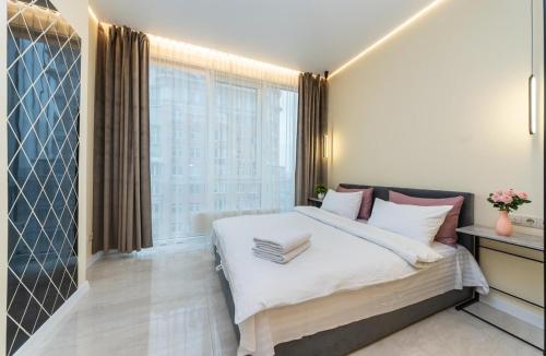 a bedroom with a large bed and a large window at Comfort Apartment near Minskaya metro station and DreamTown in Kyiv