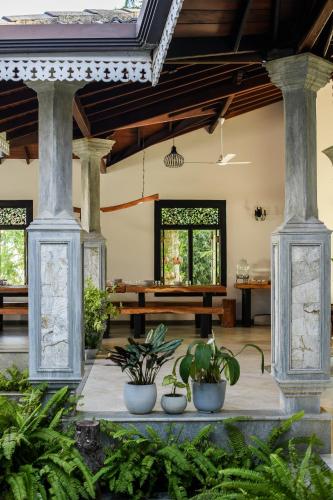 a living room with two columns and plants at Roots Retreat in Unawatuna
