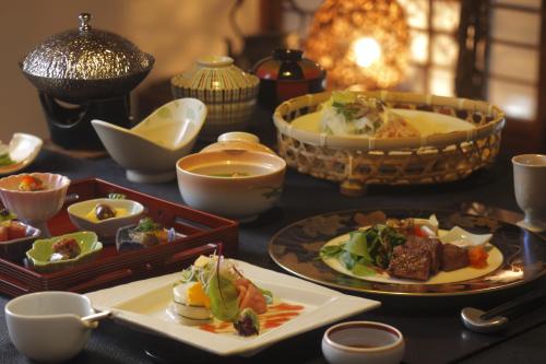 白石市にあるTokinenoyado Yunushi Ichijohのテーブルの上に食べ物の皿が置かれたテーブル
