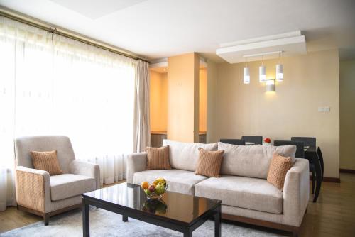 a living room with a couch and a coffee table at Fedha Residences by Trianum in Nairobi
