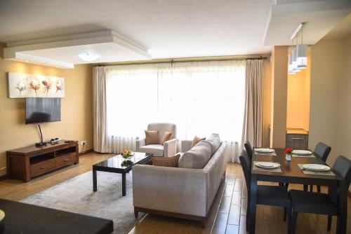 a living room with a couch and a table at Fedha Residences by Trianum in Nairobi