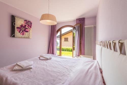 a bedroom with a white bed and a window at Il Borgo Apartment Menaggio in Menaggio